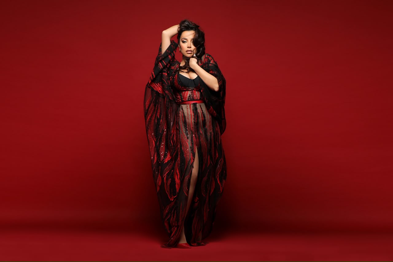 Jana Rouhana standing in her red and black gown against a red backdrop