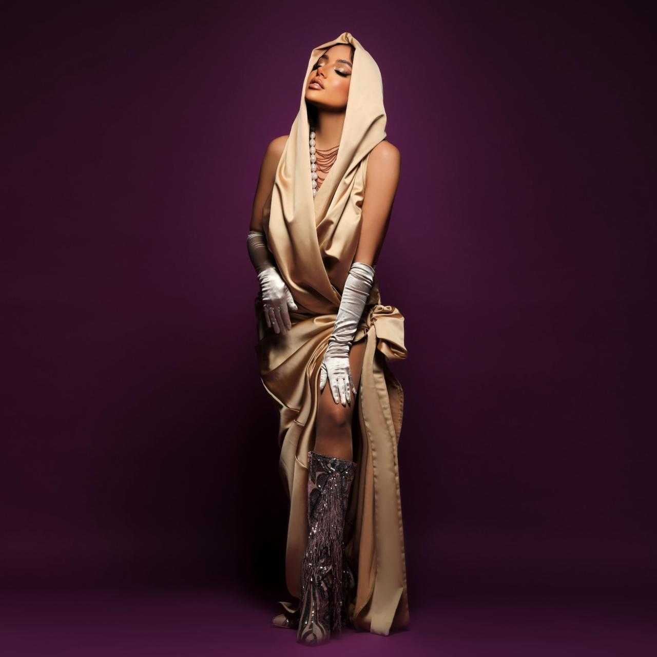 Jana Rouhana in a champagne-gold hooded gown with silver gloves and boots